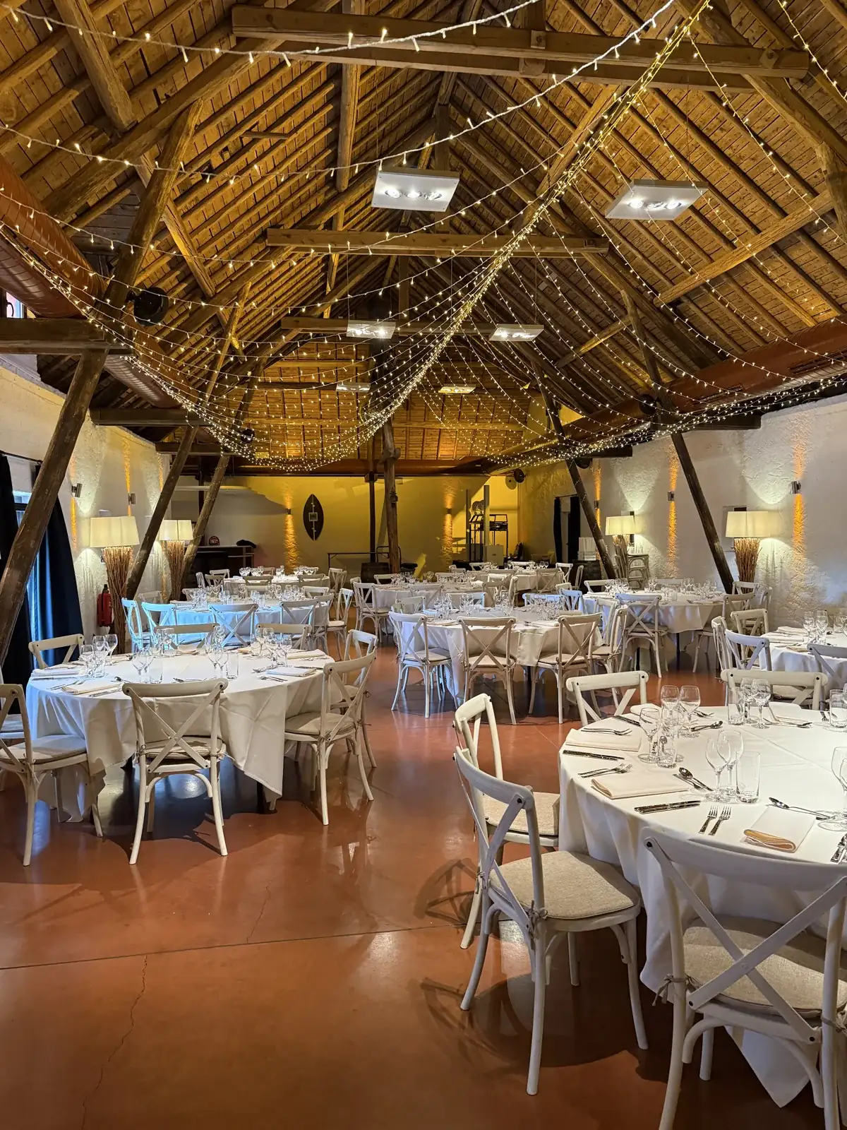 Salle de mariage au Greiwels Haff avec charpente apparente et guirlandes lumineuses