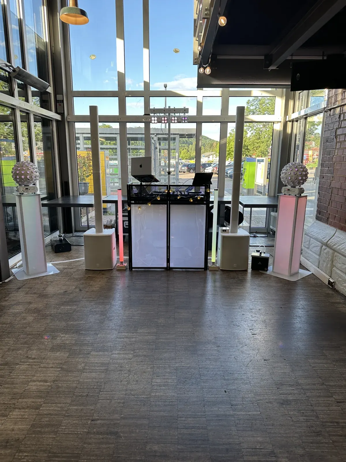 Régie DJ avec enceintes blanches et éclairage devant la façade vitrée du Stellwerk 13 à Eppelborn