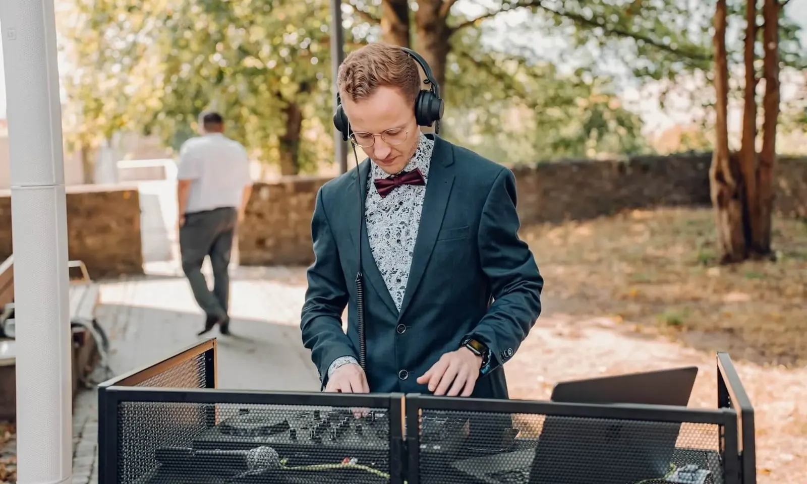 Jannik Trenz wearing headphones at the DJ booth at an outdoor wedding