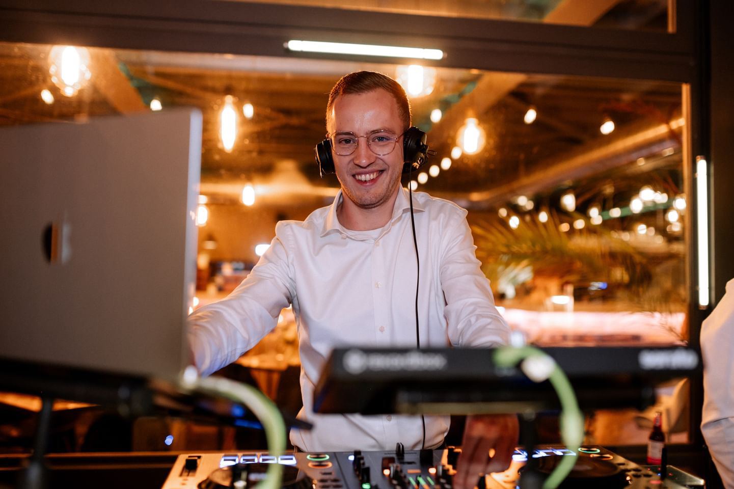 Jannik lächelt mit Kopfhörern am DJ-Pult